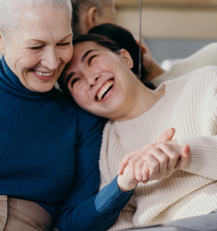 Two women embracing warmly at home